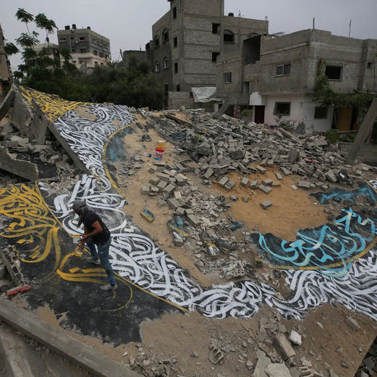 Palestinian Artist Ayman Al Hossary creates Calligraffiti amidst the rubble of a home in Gaza